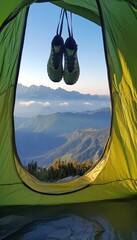 mountain view from inside the tent with trekking shoes hanging on the tent door