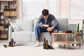 Young man drinking whiskey at home.  Alcoholism concept