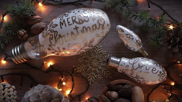 Decoraci&oacute;n de Navidad hecha a mano con focos reciclados, pi&ntilde;as, ramas de pino, luces. Handlettering: Merry Christmas, love. DIY