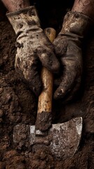 Close-up of gloved hands using a tool to dig in dark, moist soil.
