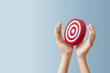A pair of hands holding a red target symbol, representing focus, goals, or precision in marketing or business strategies.