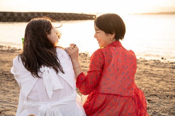 Two Women Relaxing on the Beach at Sunset