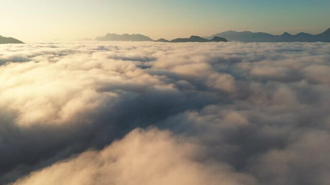 Aerial time lapse above the clouds while sunrise sky. A sea of fog is formed from stratus. Foggy valley mount ridge nature. Tim lapse cloudy formation slow 