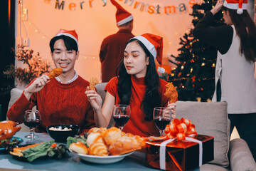 Group of young Asian man and women as friends having fun at a New Year's celebration, holding gift...