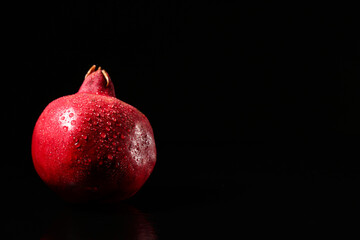 Tasty ripe pomegranate on black background, closeup