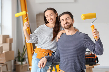 Young couple with paint rollers during repair in their new house