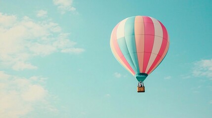 Naklejka premium Pastel Hot Air Balloon Soaring in a Blue Sky