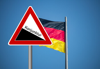 Flagge von Deutschland und Verkehrsschild als Symbol für sinkende Konjunktur