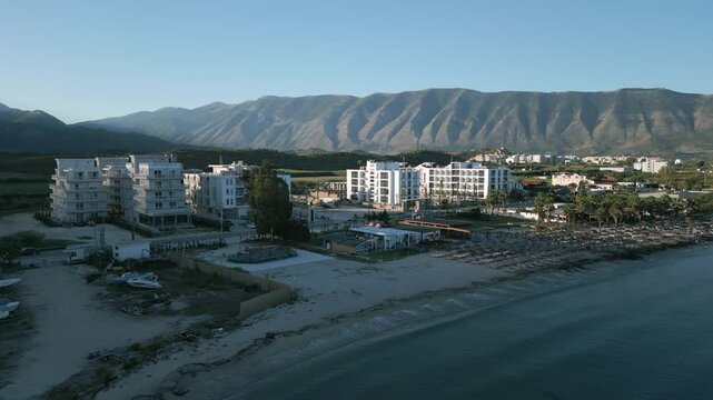 Beachfront hotels with mountain views in Orikum Albania, captured at sunrise with a tranquil vibe