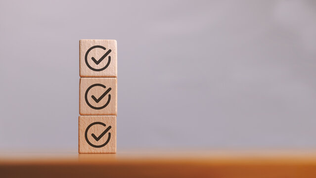 Stacked wooden cube block with check mark icon represent job checklist or task list in survey or assessment confirmation item in quality control, business goal and achievement concept.