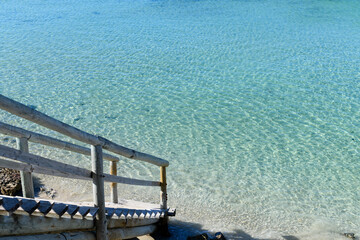 Wooden steps with turquoise ocean summer background