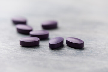 Lutein tablets. Dietary supplement on wooden background. Soft focus. Close up. Copy space	