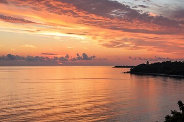 Fototapeta premium Softly glowing sunset over a serene ocean, light blue sky, peaceful atmosphere, sunset colors, ocean waves, serene landscape