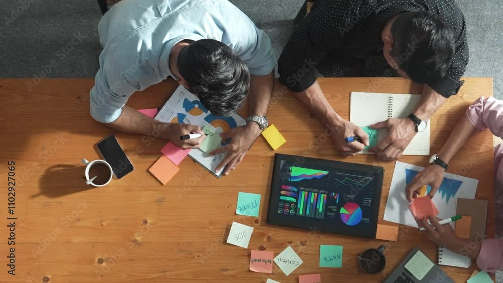 Poster top aerial view of diverse team writing colorful sticky notes to brainstorm marketing idea while loo