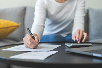 Deduction planning concept. Asian young woman hand using calculator to calculating balance prepare...
