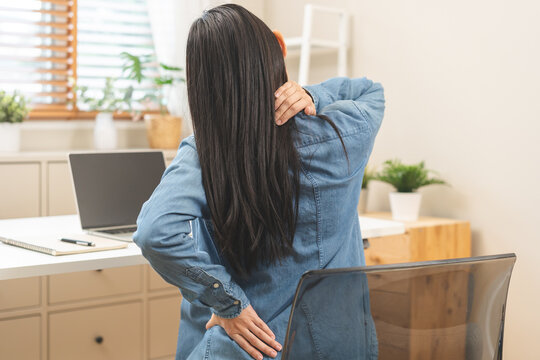 Body muscles hurt stiff, suffering asian young woman, girl back pain, body ache while sitting work at desk, hand holding massaging rubbing back, problem health care of office syndrome people concept.