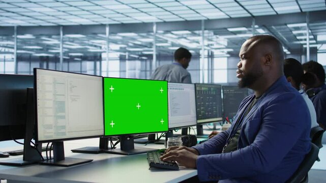 Engineer using green screen computer in server room, developing disaster recovery plans ensuring minimal downtime. Data center worker looking at mockup PC, monitoring performance, camera A