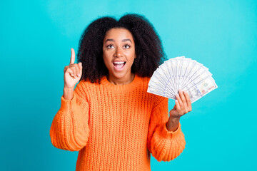 Photo of lovely young lady hold money fan eureka point look up wear stylish knitted orange garment isolated on aquamarine color background