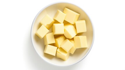 Fresh butter cubes arranged in a bowl on a white background captured from above showcasing delicious culinary ingredients for recipes