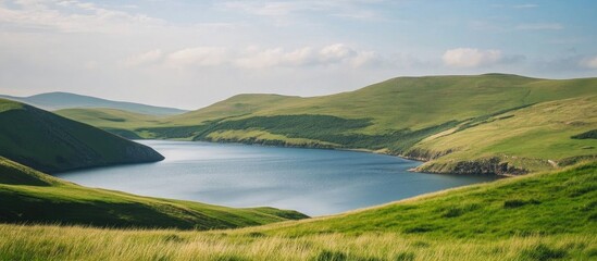 Breathtaking countryside landscape showcasing rolling hills and serene bodies of water under a clear blue sky