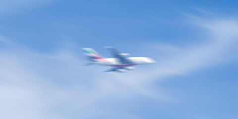 Motion blur background with sky scenery and airplane. blurry blue sky and partially cloudy