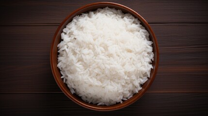 Bowl of freshly cooked fluffy white rice on wooden table top view delicious and nutritious staple food for various cuisines