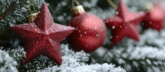 Decorative red star-shaped Christmas ornaments on a snow-covered evergreen tree close up festive holiday charm