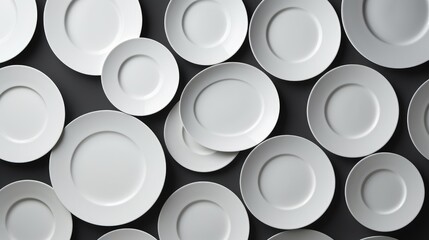 Aerial view of white ceramic plates arranged on a black background showcasing minimalist design and texture for culinary or table setting use.