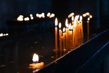 Burning church candles on black background
