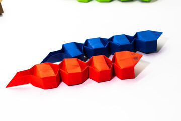 Snake made of paper on white background. Origami snake. Symbol of the new year 2025