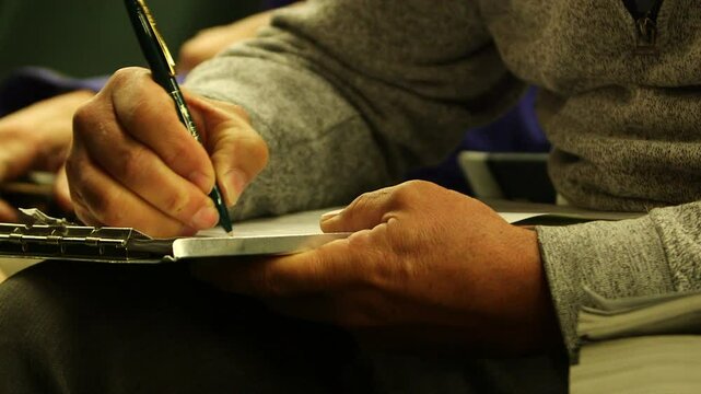 close up of a person taking notes on paper