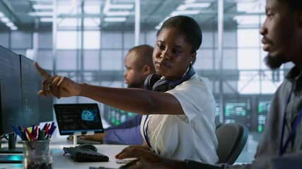 Coworker giving server hub engineer insights into developing disaster recovery plans ensuring minimal downtime. Worker helping colleague in data center monitoring performance, camera A