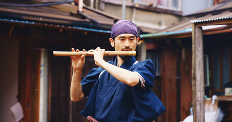 Japanese man, flute and music for practice, reflection and zen sound for Shinto meditation. Sensei person, bamboo and fue instrument for tradition, culture and spiritual heritage with shinobue
