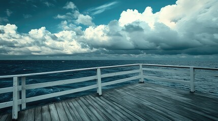 Wooden deck on a cruise ship with a white railing overlooking a vast blue ocean and dynamic whitecaps beneath a cloudy sky.