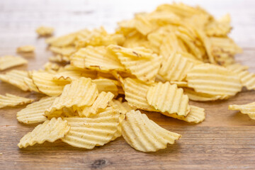 木のテーブルに広がるギザギザポテトチップス