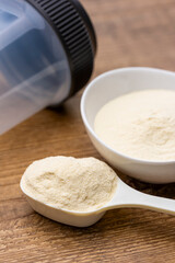 計量スプーンと白い器にプロテインそしてプロテインシェイカー