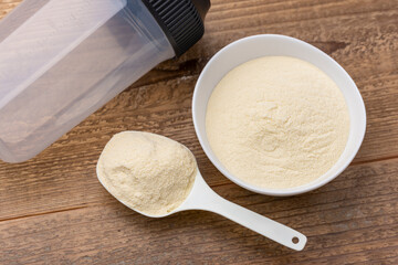 計量スプーンと白い器にプロテインそしてプロテインシェイカーの俯瞰