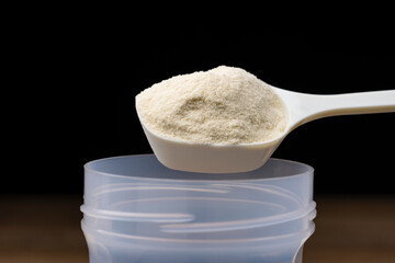 シェイカーに計量スプーンでプロテインを入れる