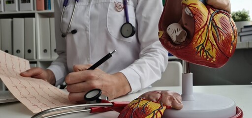 Cardiologist observes results of cardiograms and arterial hypertension
