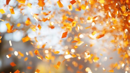 Vibrant orange confetti floats against a soft bokeh backdrop, creating a joyful and festive atmosphere filled with light and energy.