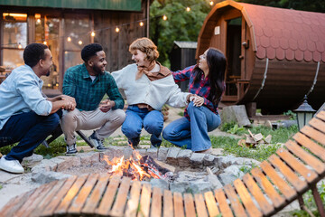 Friends enjoying a bonfire party in a cozy backyard setting