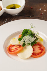 Tomato and mozzarella salad on a white porcelain plate, Caprese Salad