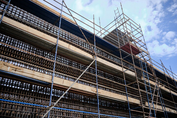 Low angle view of industrial stair tower, scaffoldings and reinforcement frame of walls at construction site