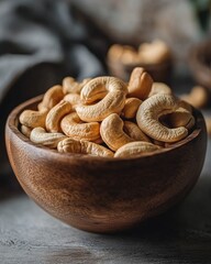 Rustic Wooden Bowl of Cashews on Textured Surface in Natural Light