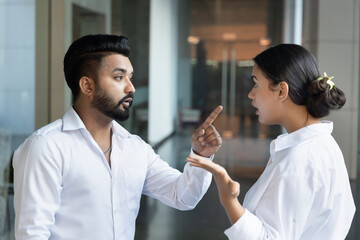Angry upset South Asian young adult man and woman colleague team, office workers or business...
