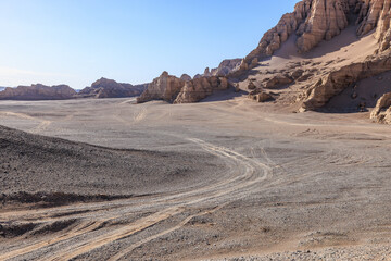 Desert sand ground and Yardang landform mountain natural landscape in Xinjiang, China. Road trip in no man's land. Outdoor natural background.