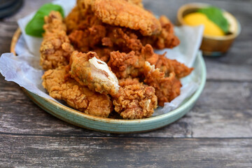 
 Crispy home made  deep fried   chicken strips . Breaded  with cornflakes chicken  breast fillets  with chilly peppers and fresh   basil on wooden rustic background