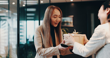 Business people, gift and celebration with bow, gratitude and congratulations. Japan, employees or consultant in office, present and event for birthday, success or promotion with respect or thank you