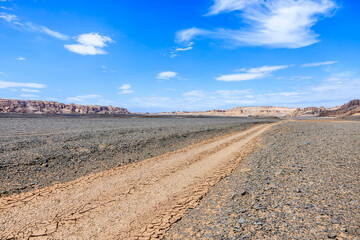 Desert dirt road natural landscape in Xinjiang, China. Road trip in no man's land. Outdoor natural background.