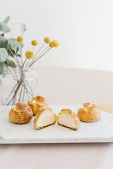 choux cream or cream puff or French profiteroles with fresh cream set on cafe table